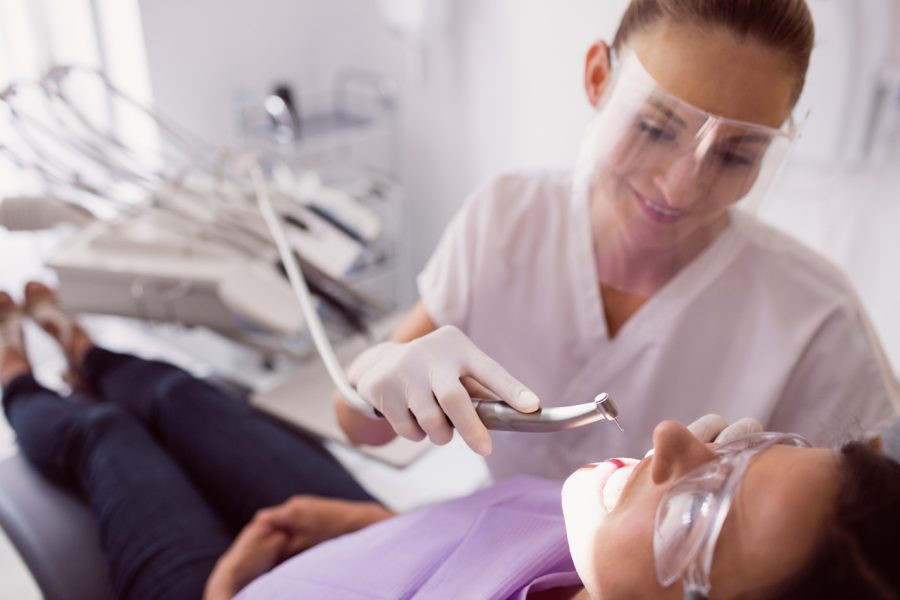 Dentist examining female patient in clinic